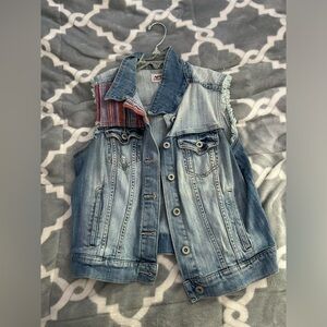 blue denim vest with a design on the collar